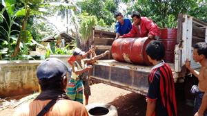 トラックから降ろされるドラム缶