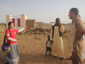 門だけが残った家の前で話を聞くAARの川越