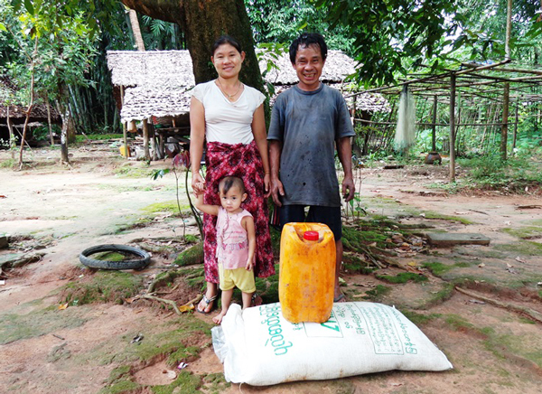 支援物資を前に笑顔を見せる夫婦と子ども