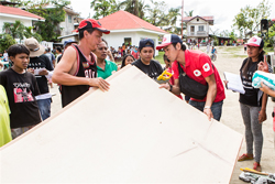 大きな合板を持つAARスタッフと受け取りに来た被災者の方