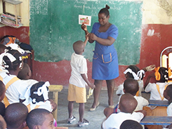 教室で、先生の持つイラストカードを指さす児童