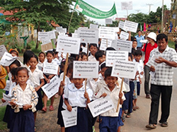 スローガンを掲げて行進する子どもたち