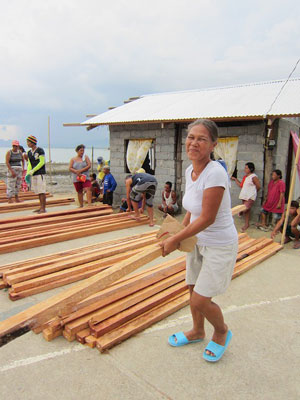 笑顔で材木を運ぶ女性