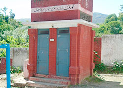 小学校の校庭にあるトイレ。レンガ造りで、屋上に給水タンクが設置されています。