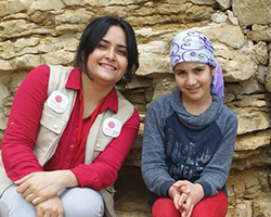 ネスリンさんと、AAR職員が肩を寄せ合って座っている様子