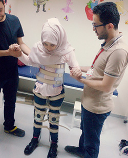 歩行の練習をするサーラさんと、彼女を支えるAAR職員