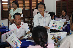 イラストの描かれた紙をもって発表する女性