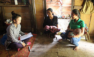 赤ちゃんを抱く女性に話を聞く2人の女性