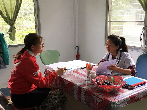 机に座って話す二人の女性