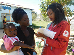 赤ちゃんを抱えたお母さんに話を聞くサロメ