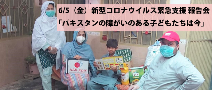 AAR現地スタッフと、物資を届けた家族がカメラに向かい微笑む。椅子に座った男の子の横には、緊急支援物資の衛生用品や食料が並ぶ