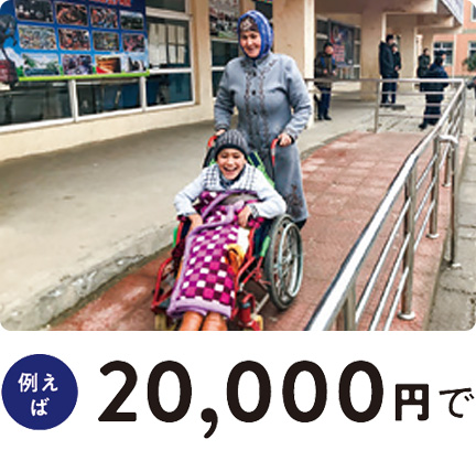 タジキスタンで、車いすに乗った人と、車いすを押す人がスロープ上を歩いている